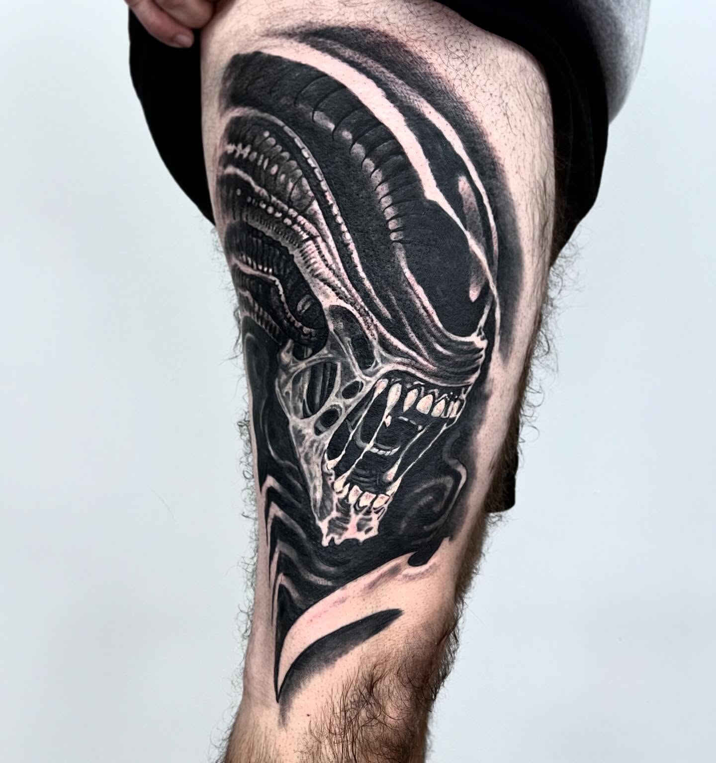 Alien head realism tattoo on the thigh by Briana Walker