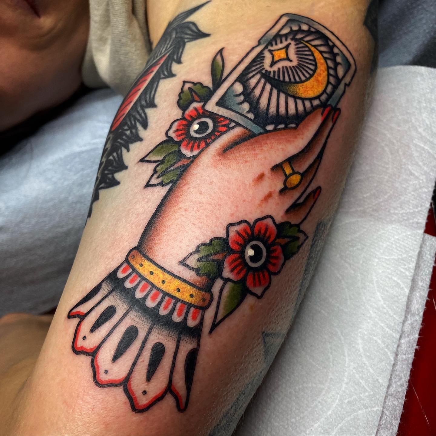Hand holding playing card American traditional tattoo on the forearm by andrewtattoos