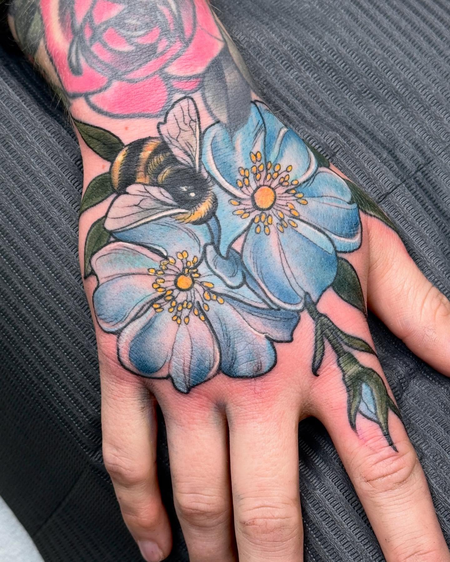 Flowers and bee realism tattoo on the hand by Rachael Shelly
