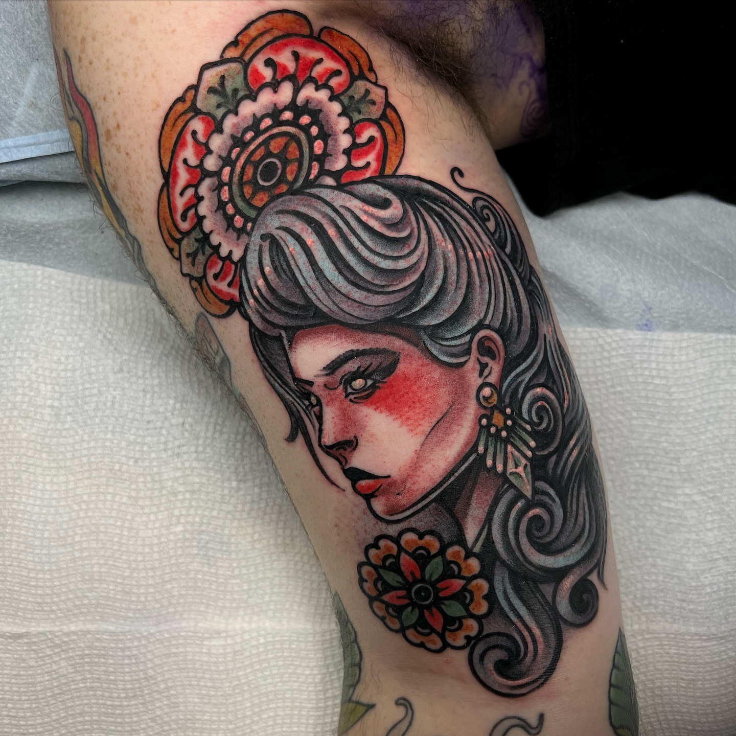 Woman with floral headdress American traditional tattoo on the forearm by Fredd Chino