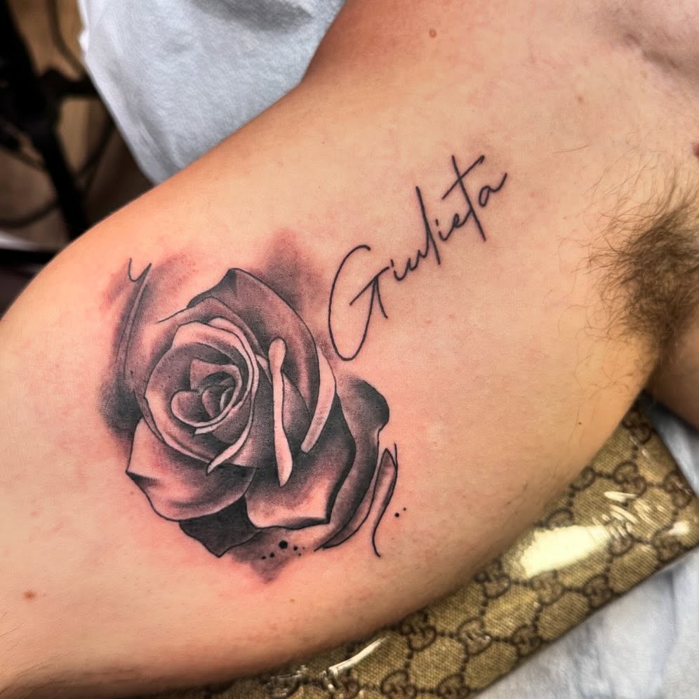 Rose black and grey tattoo on the upper arm by Diana Kunz