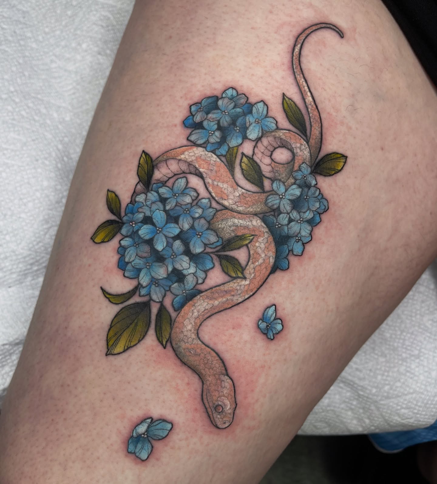Snake and flowers realism tattoo on the thigh by Lexx Christine