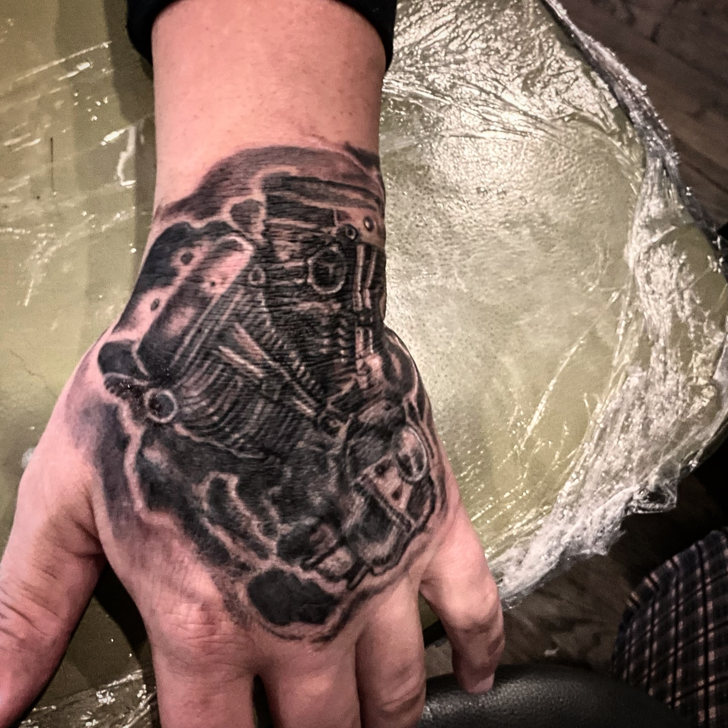 Engine black and grey tattoo on the hand by Matthew Clanin