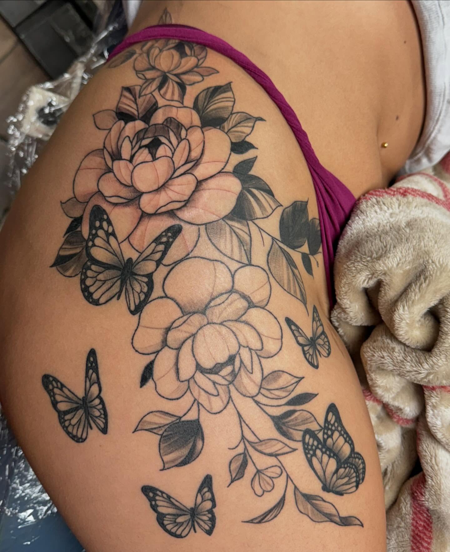 Flowers and butterflies black and grey tattoo on the thigh by Mickey
