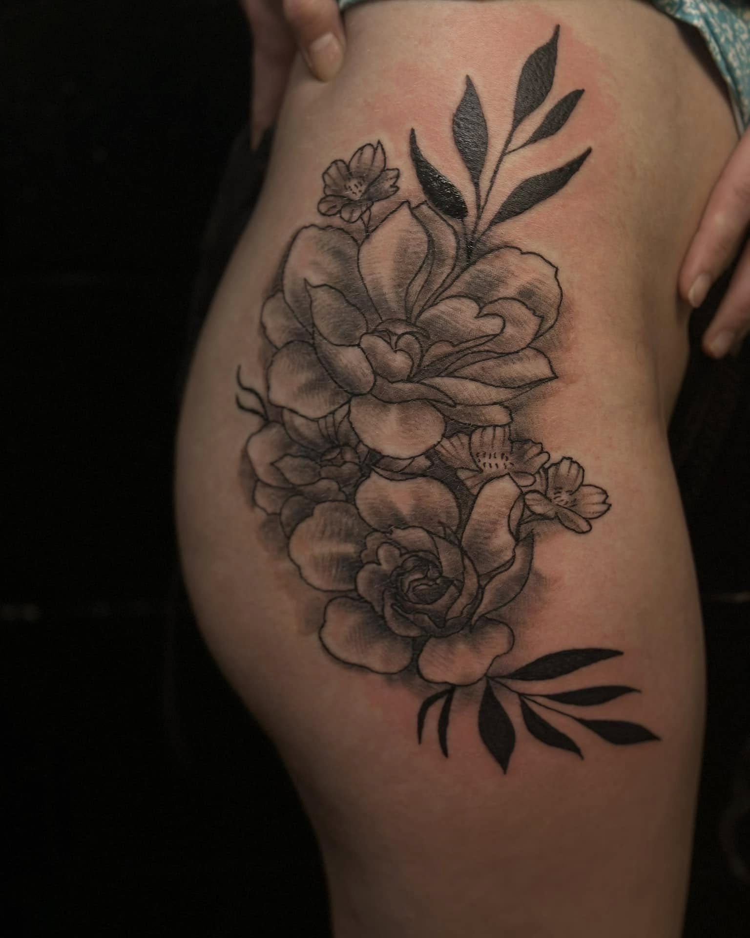 Floral bouquet black and grey tattoo on the thigh by Aj Negrete Jr.