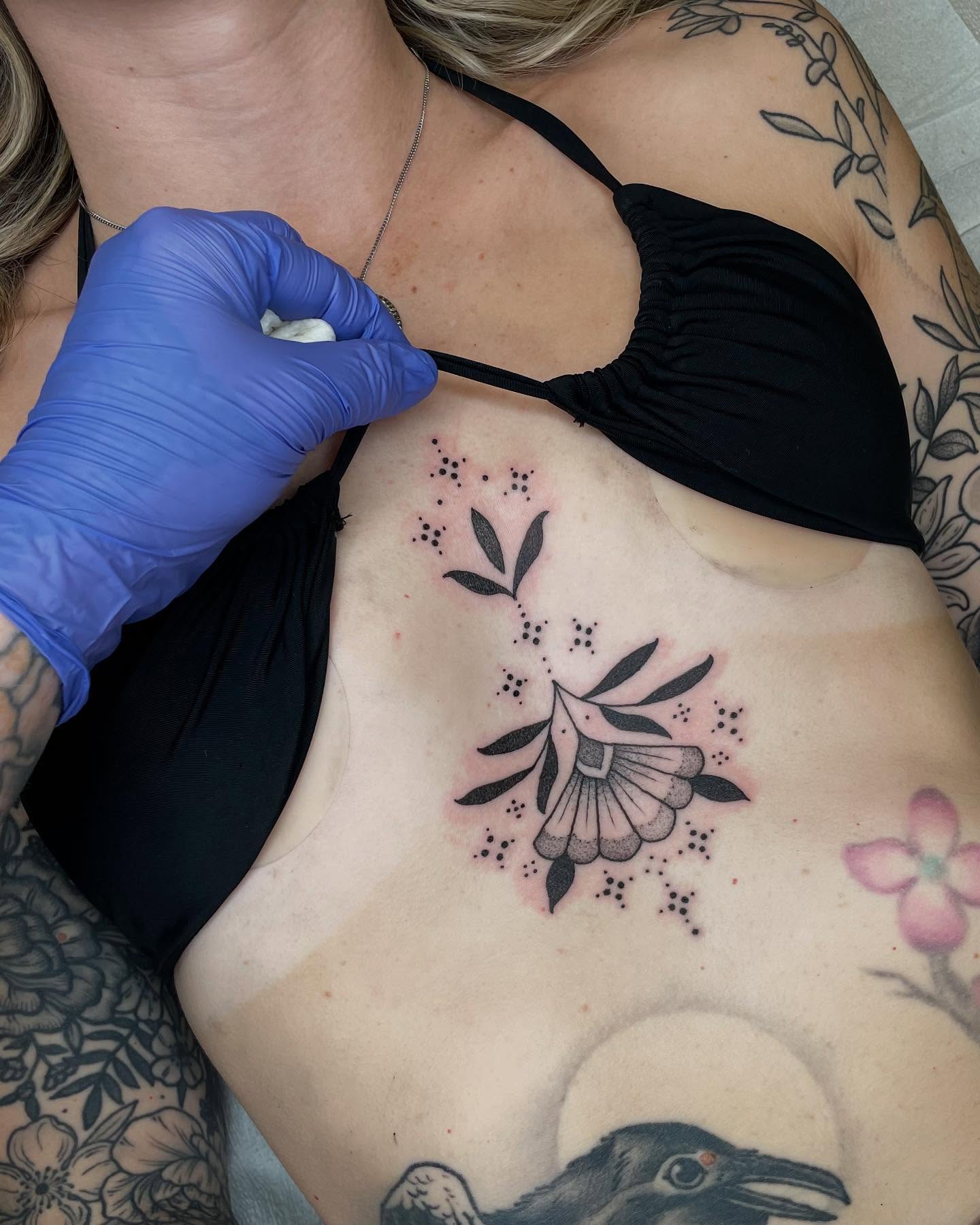 Flower dotwork tattoo on the chest by Emily Lux