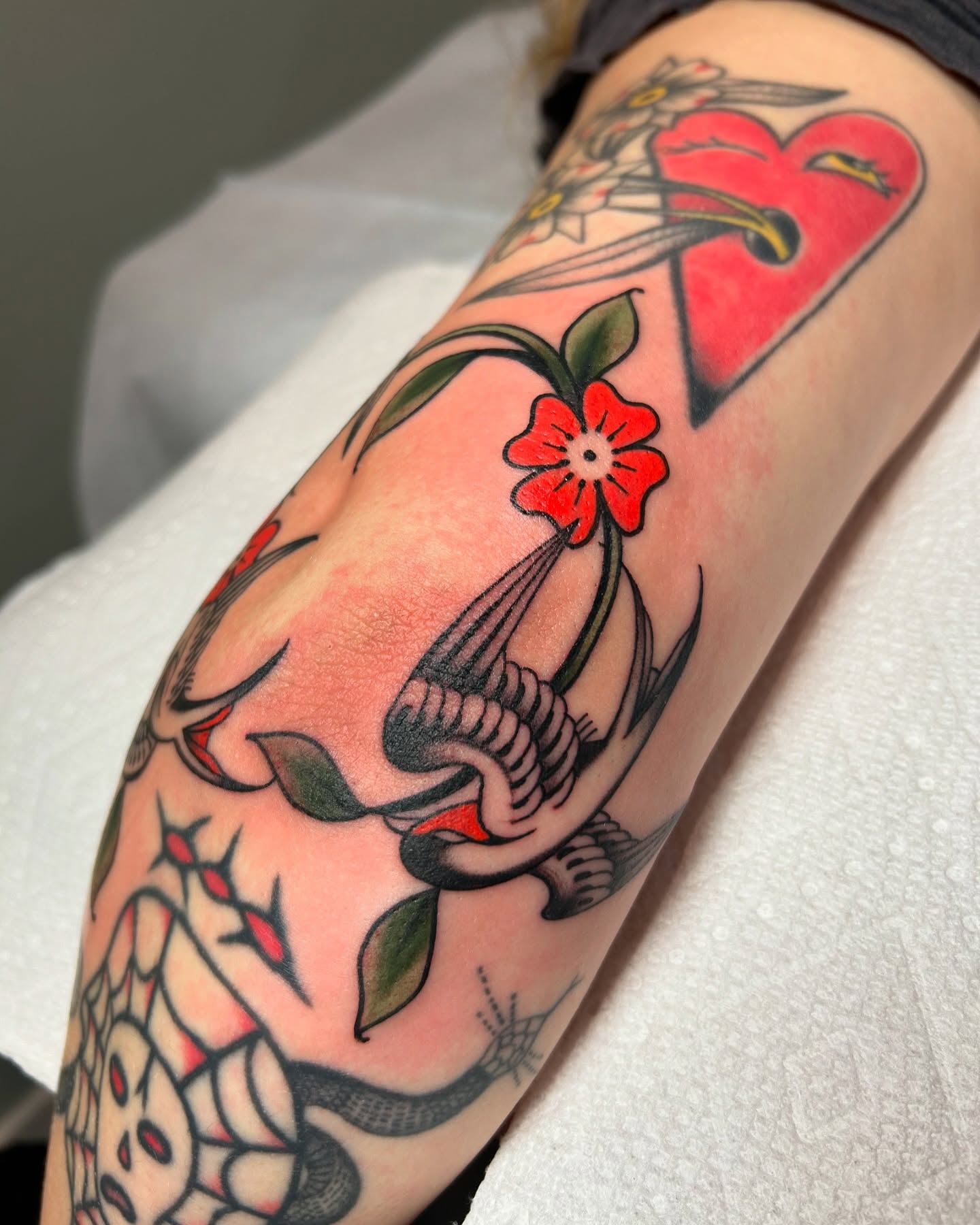 Bird and flower American traditional tattoo on the forearm by Lilly Binns