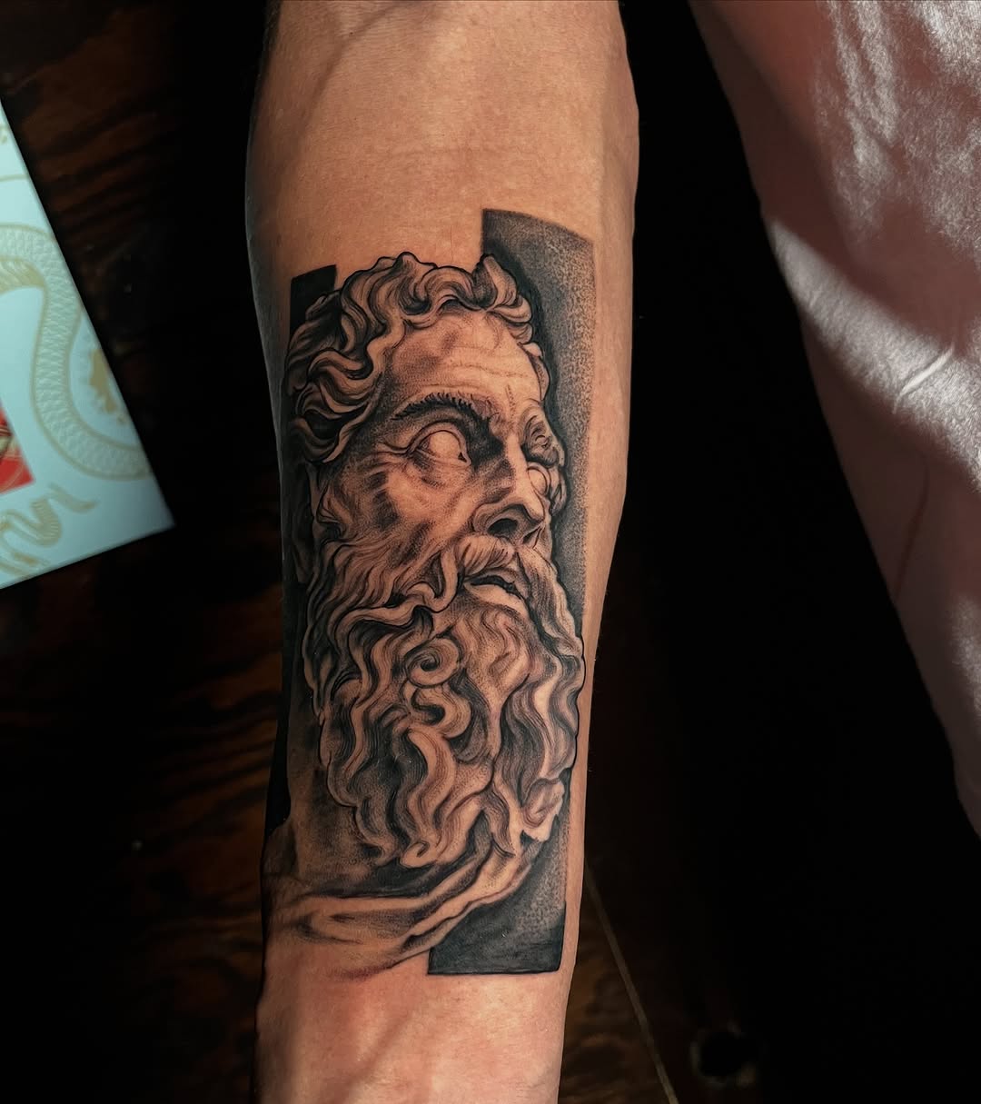 Bust of a bearded man surrealism tattoo on the forearm by "el asere, el zurdo"