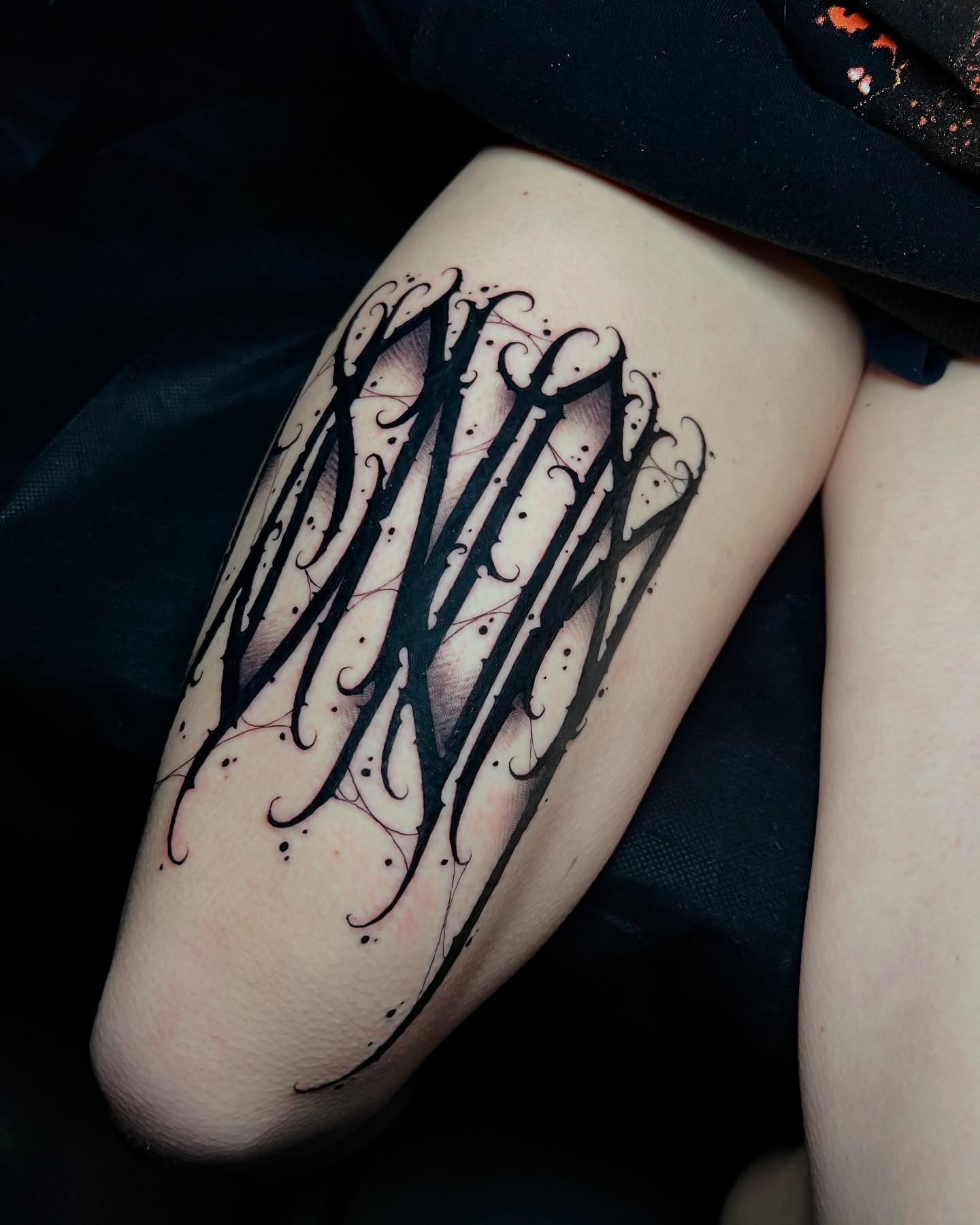 Gothic script blackwork tattoo on the thigh by James Foltz