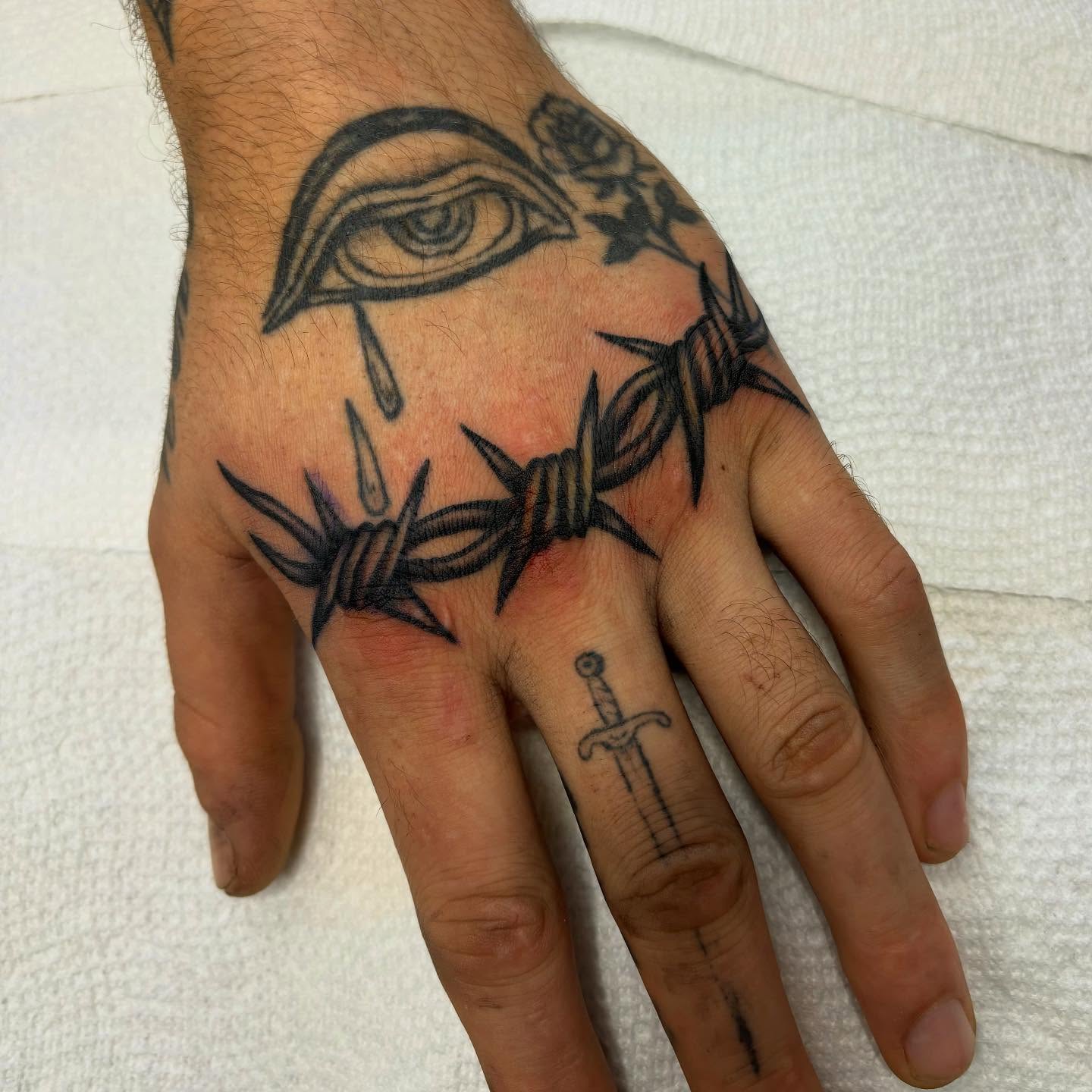 Barbed wire and eye black and grey tattoo on the hand by ⟡ Sam O ⟡