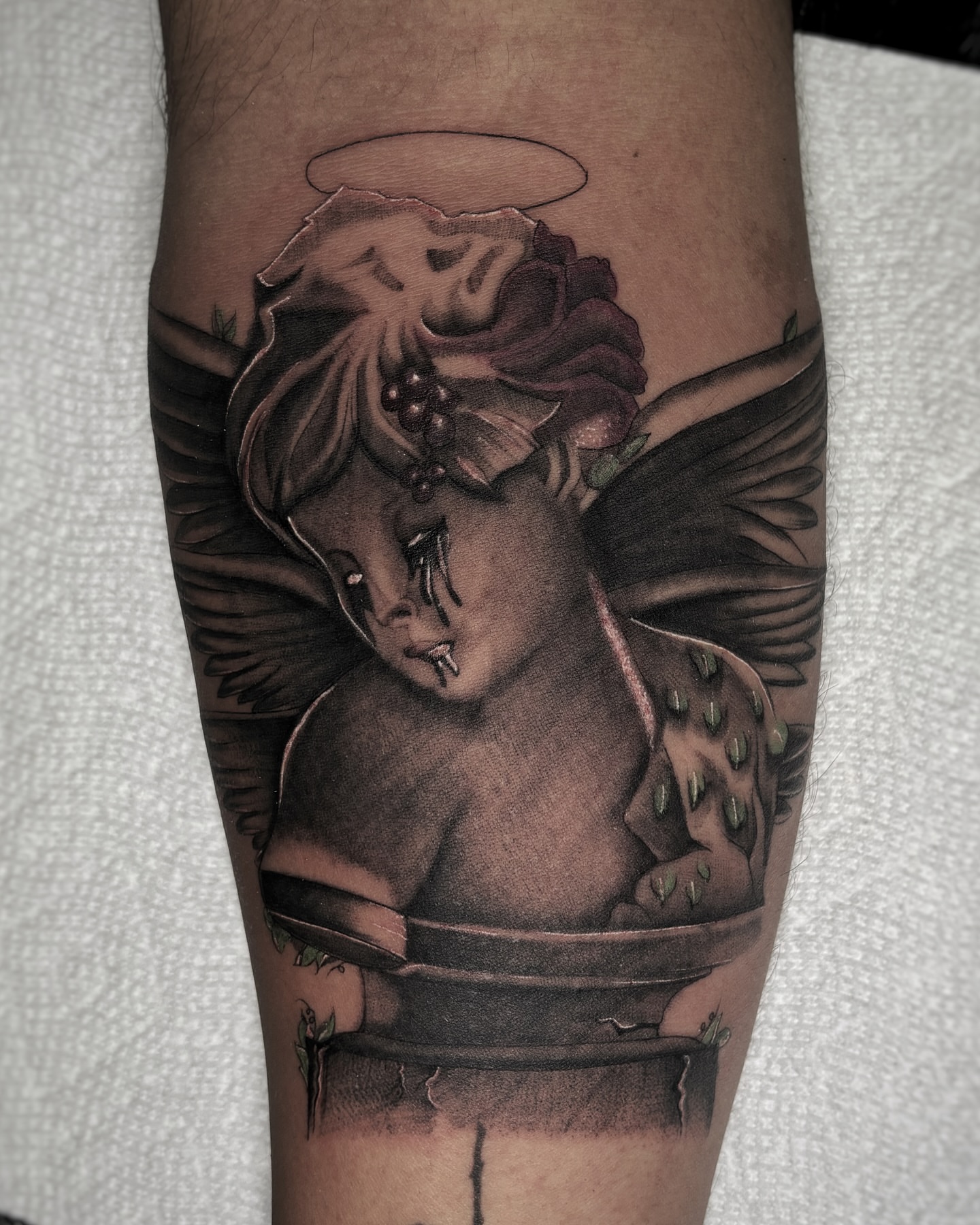 Cherub with halo realism tattoo on the forearm by Alejo Ibanez Tattoo