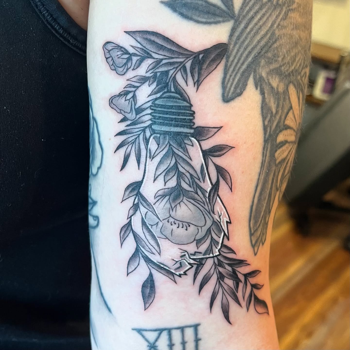 Light bulb with floral elements realism tattoo on the forearm by Krystal ✨