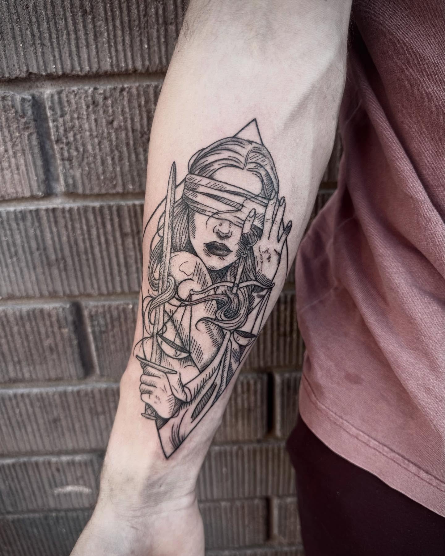 Woman with blindfold and arrow black and grey tattoo on the forearm by Jianna