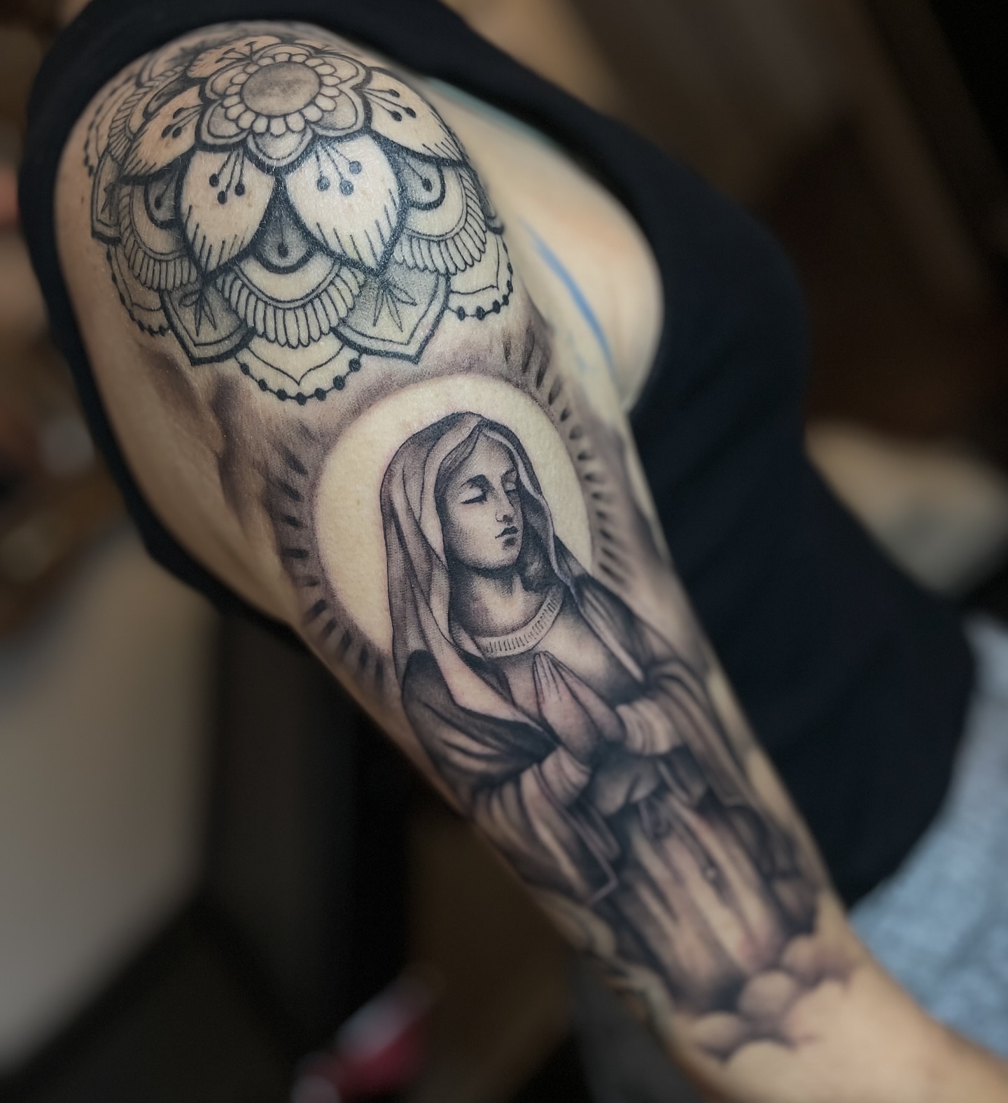 Religious figure realism tattoo on the upper arm by Erica Olivier
