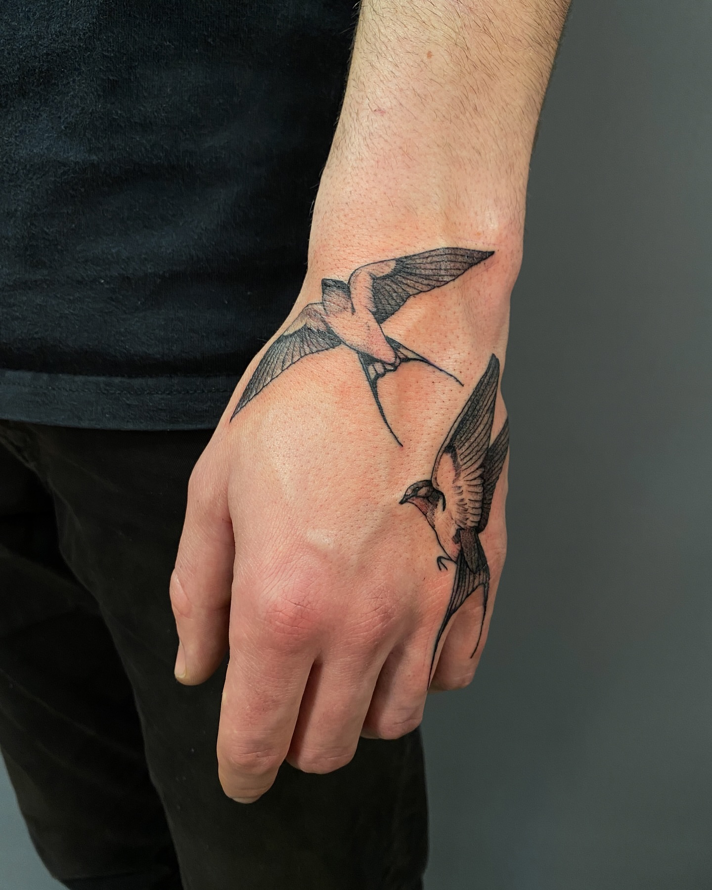 Birds black and grey tattoo on the hand by Tattoo Artist