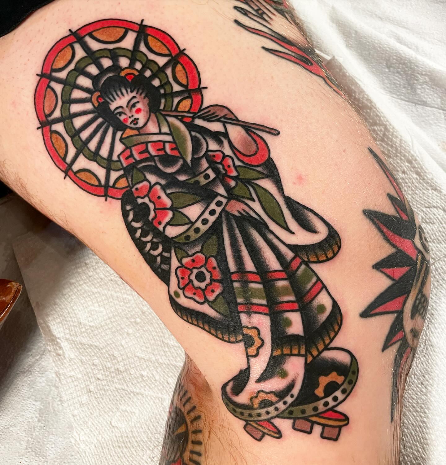 Geisha American traditional tattoo on the thigh by Mike Hudgins