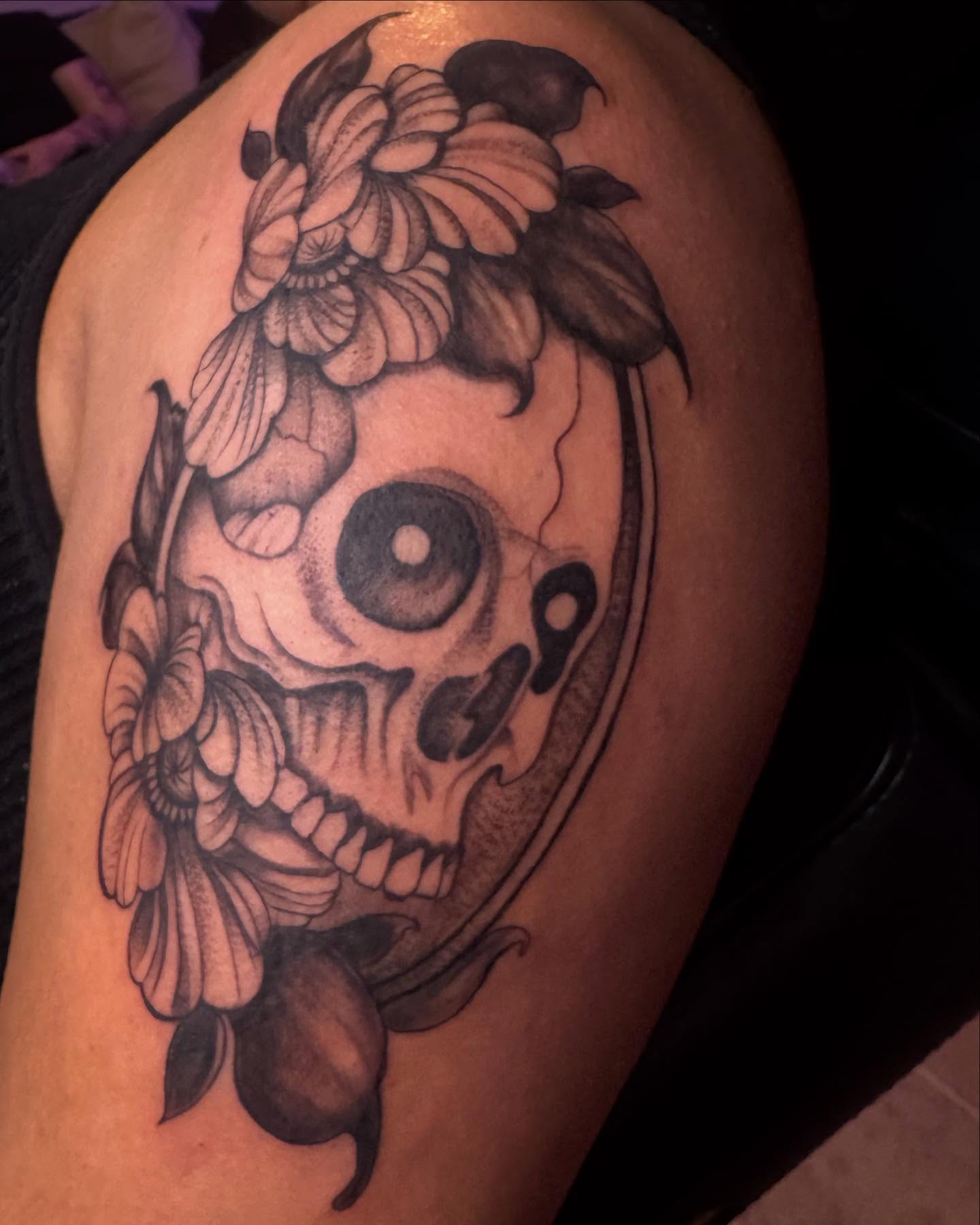 Skull with flowers realism tattoo on the shoulder by Sonia vidal