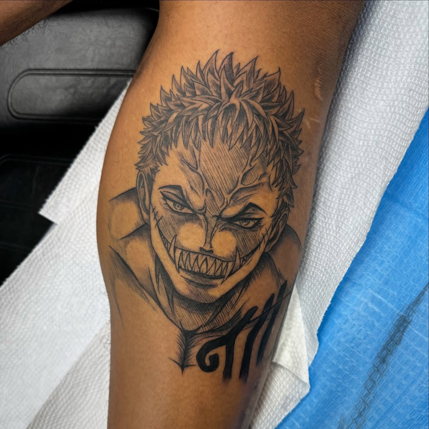 Joker black and grey tattoo on the forearm by Mike Hudson