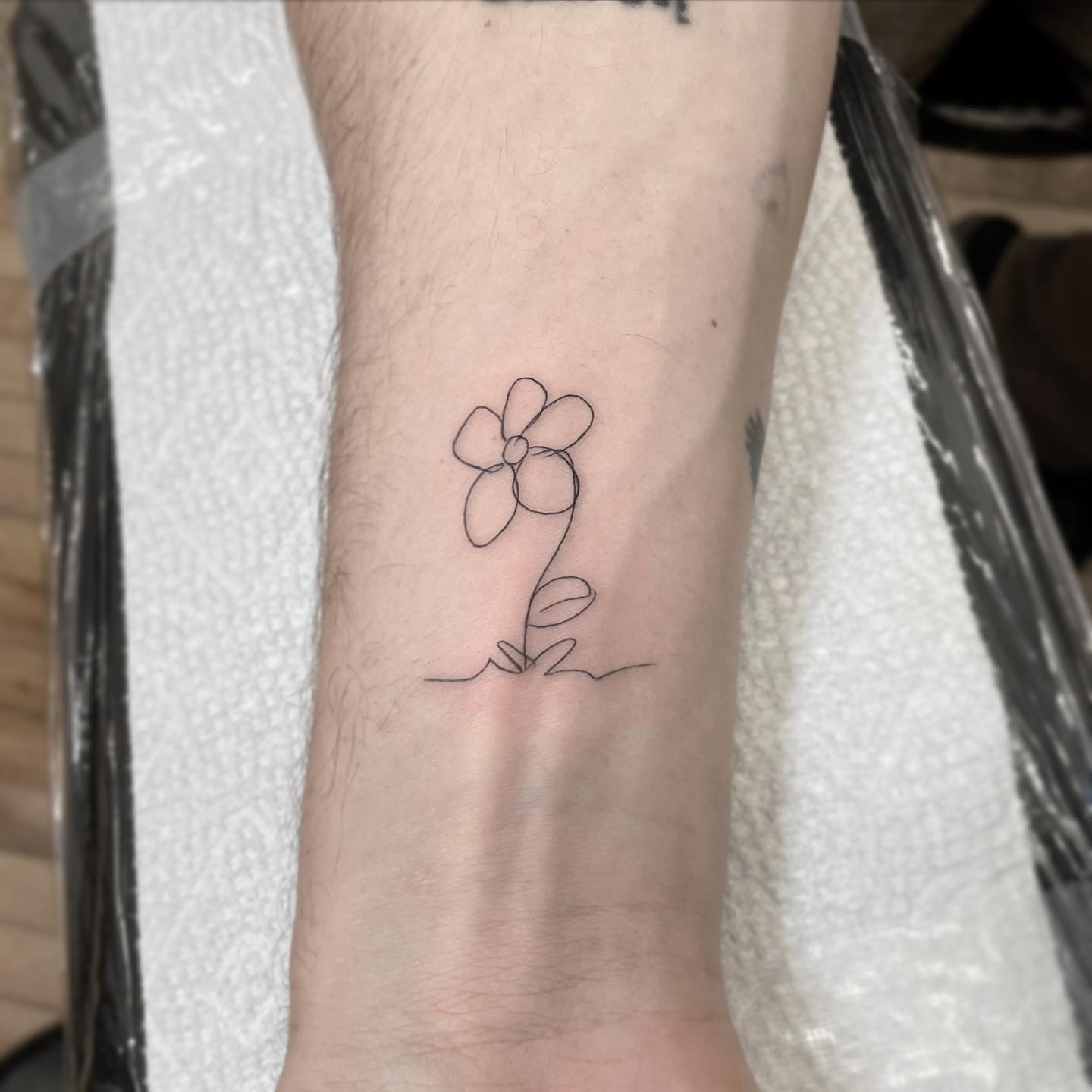 Flower minimalist tattoo on the forearm by Jesus A.