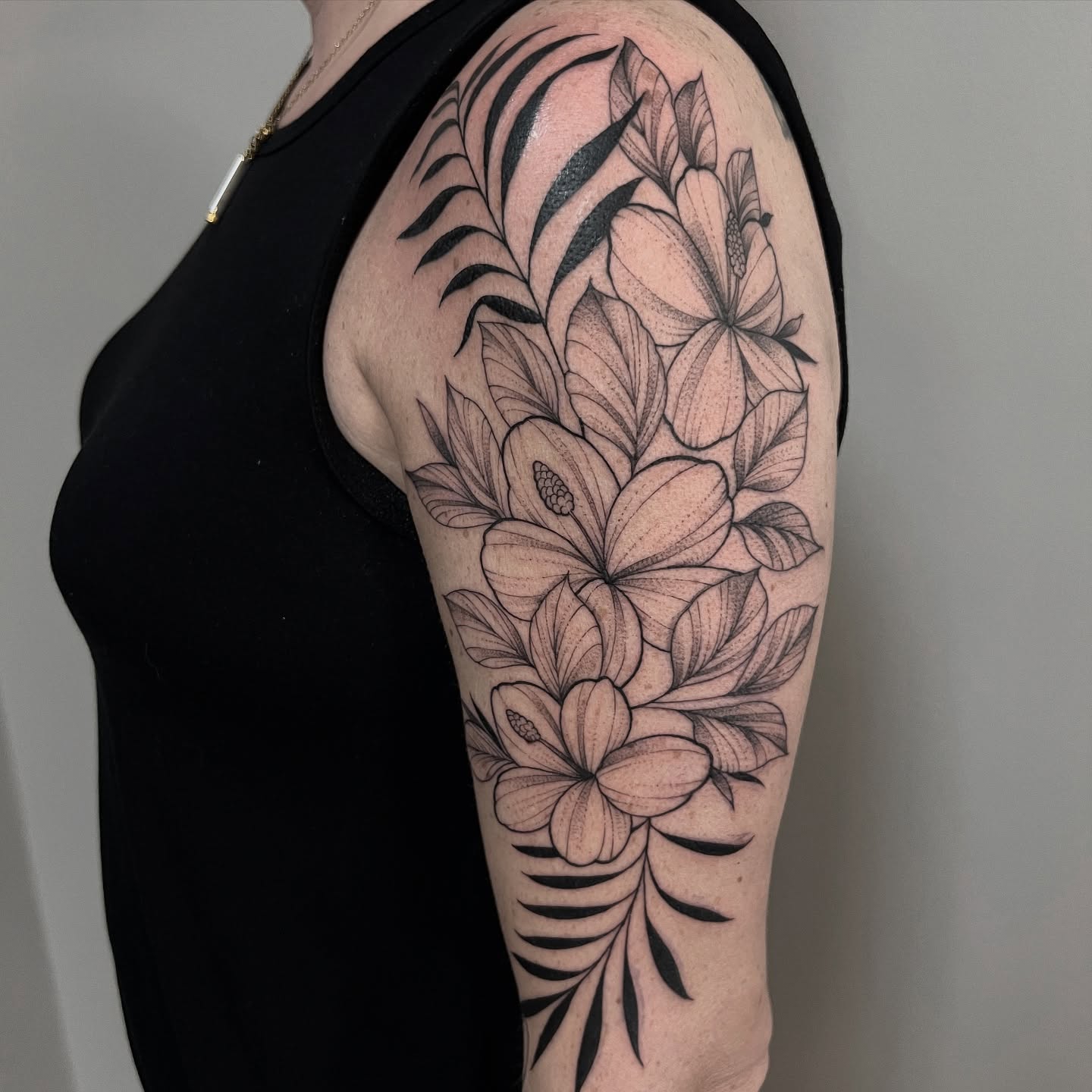 Flowers black and grey tattoo on the upper arm by Sterling Grice