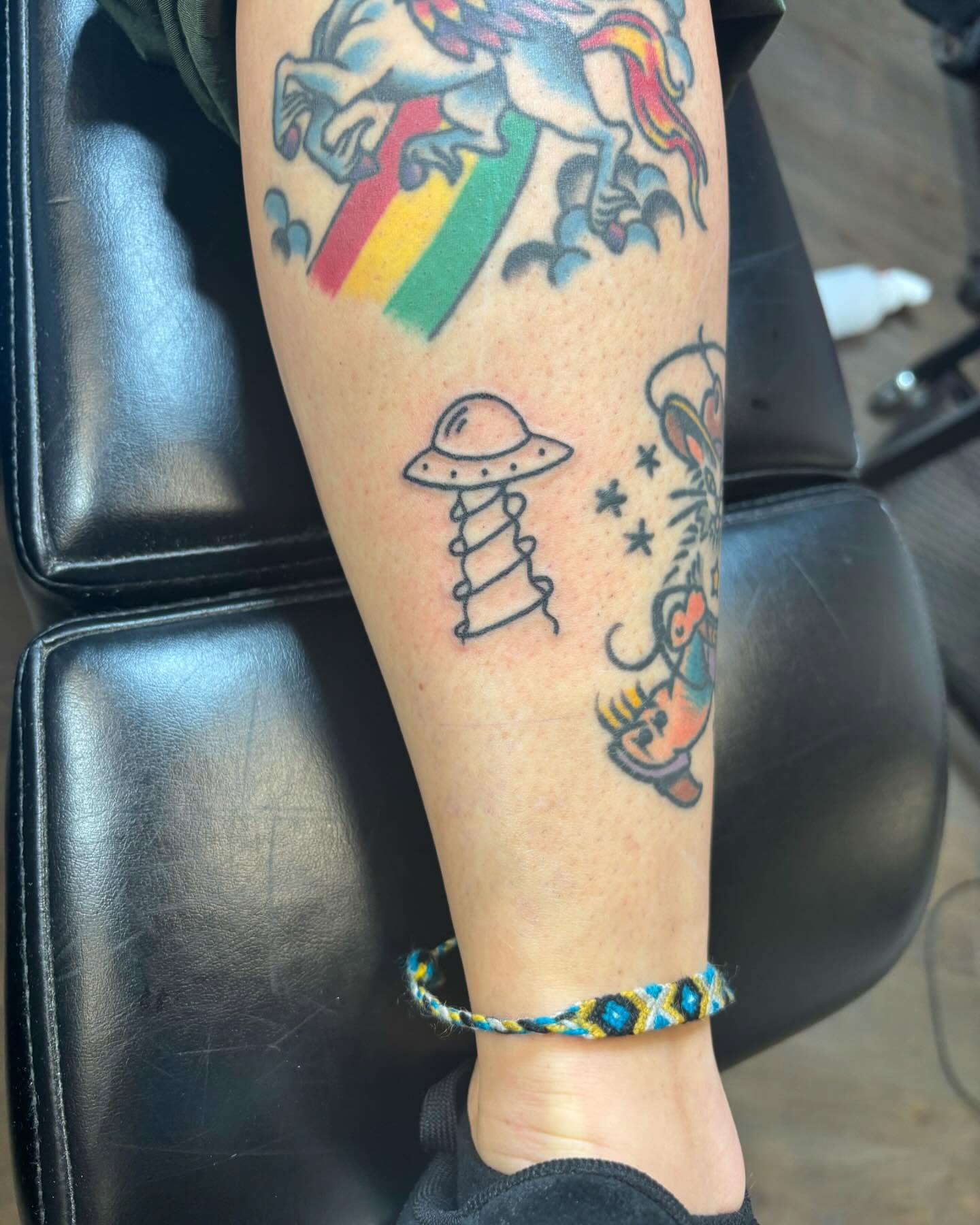 Unicorns, UFO, cartoon character American traditional tattoo on the forearm by Bryan Black