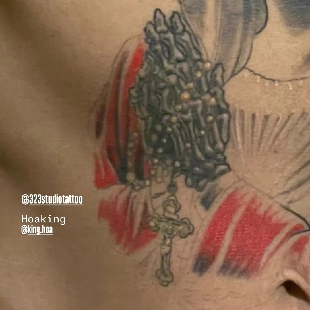 Religious cross and rosary American traditional tattoo on the chest by Hoa King