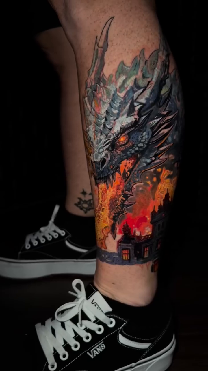 Dragon over burning city realism tattoo by Caitlyn Campbell
