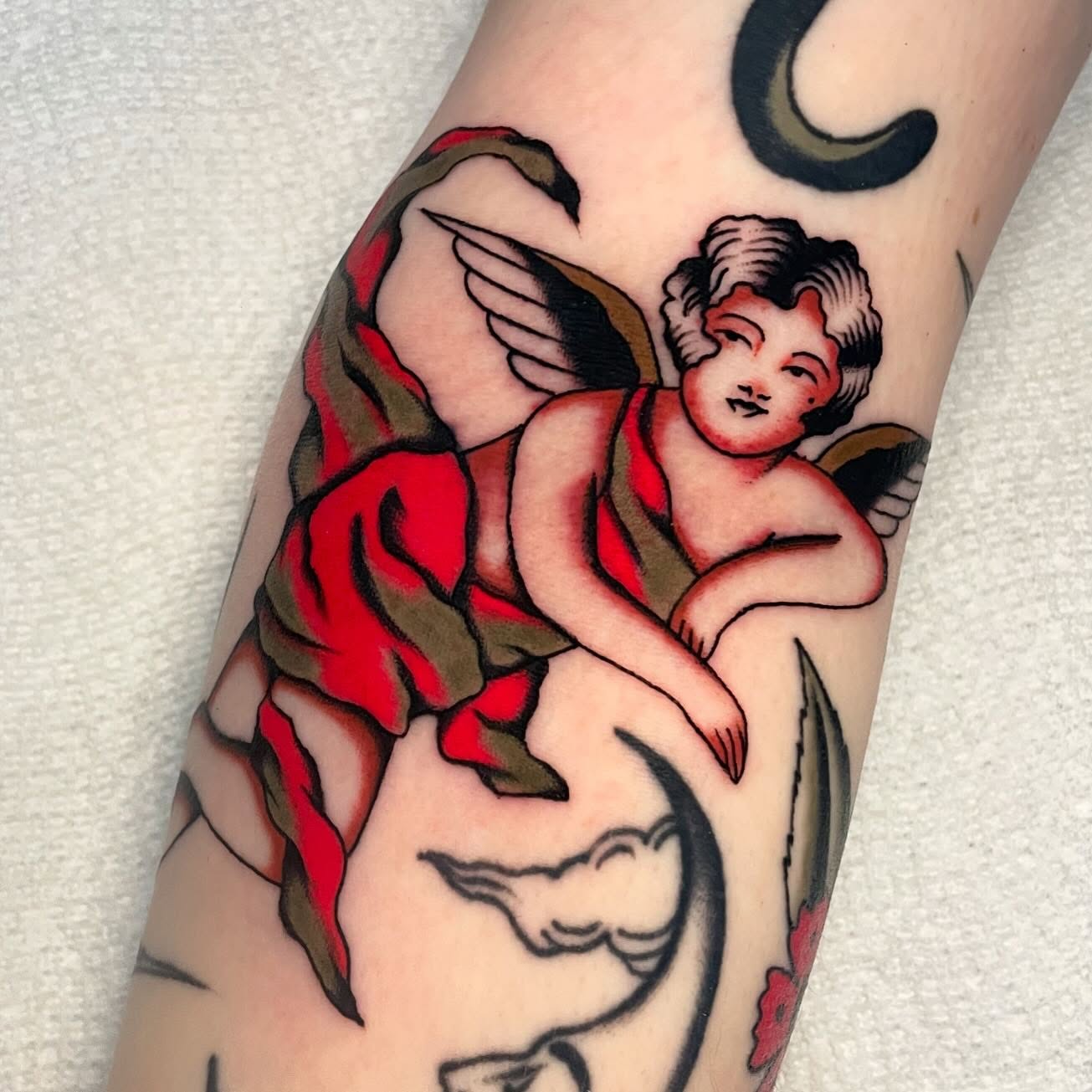 Cherub American traditional tattoo on the forearm by Toulouse Noble, Portland, Oregon