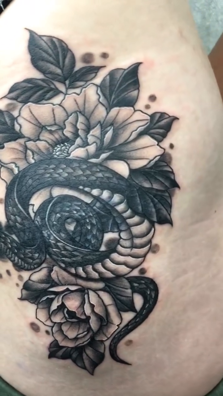Snake and flowers dotwork tattoo on the ribs by Joshua Shawn