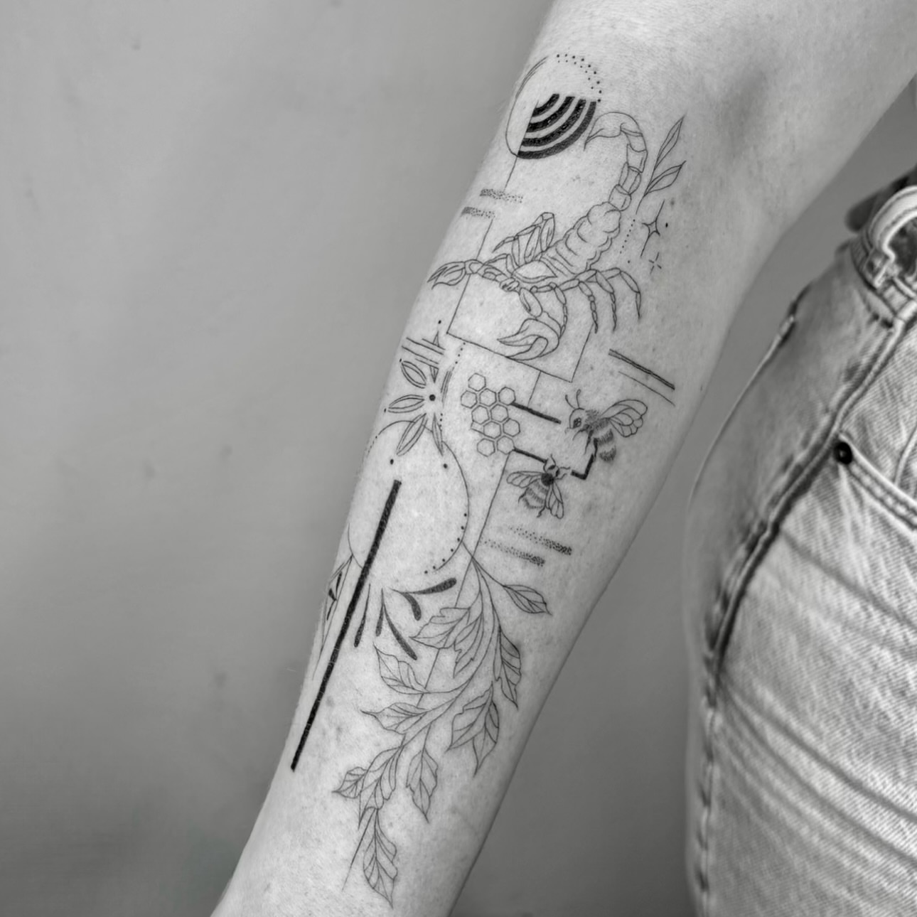 Scorpion and floral elements fine line tattoo on the forearm by Mady