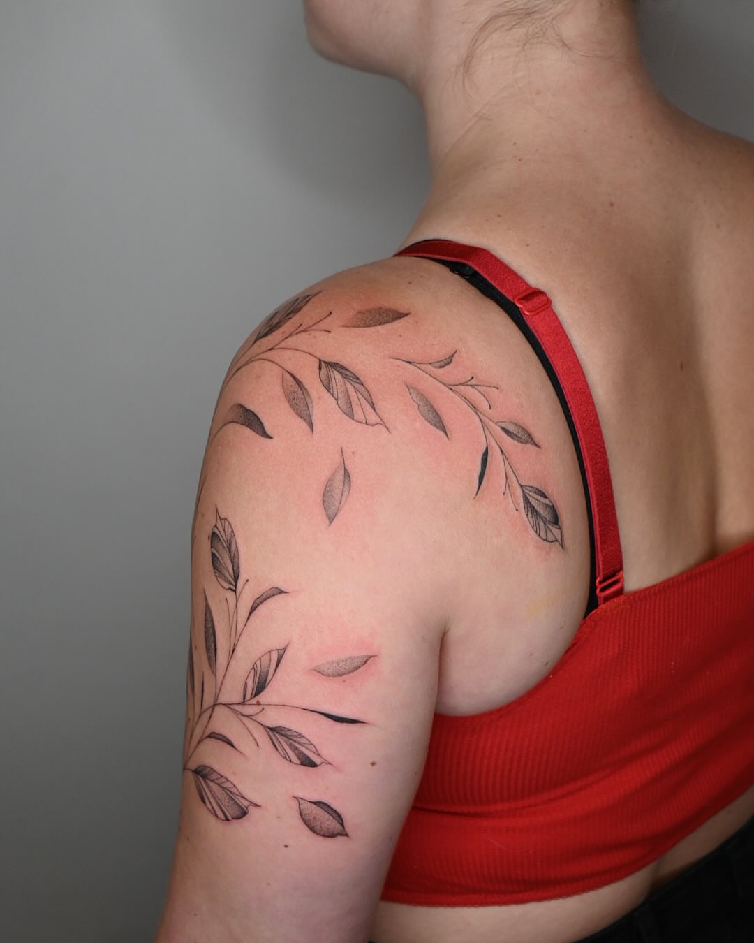 Leafy branch black and grey tattoo on the shoulder by Simba Nguyen