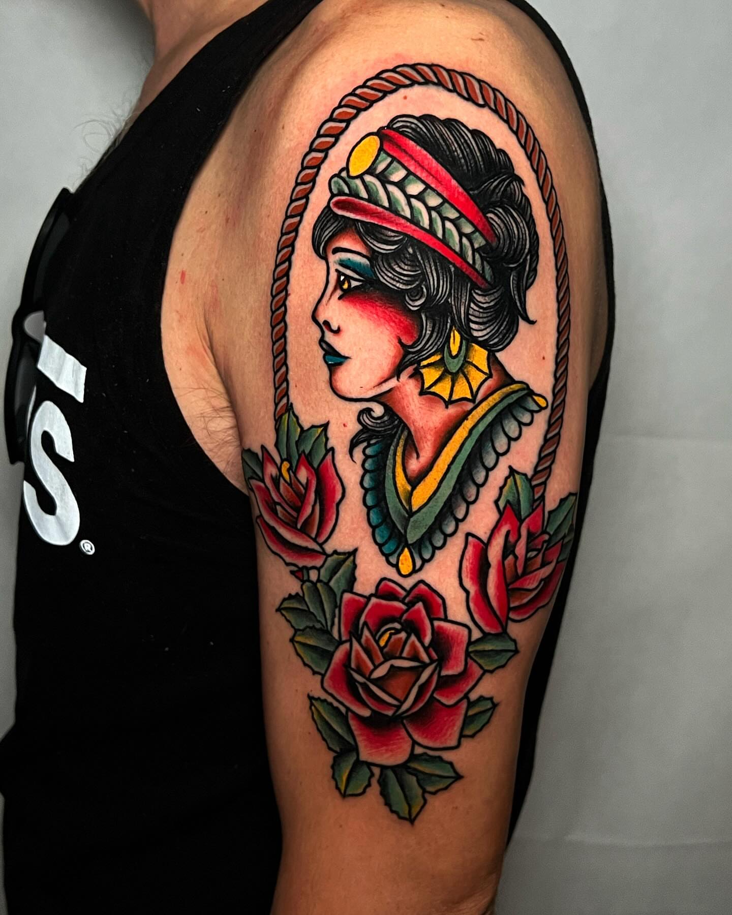Woman with roses American traditional tattoo on the upper arm by Alessandro Pennella
