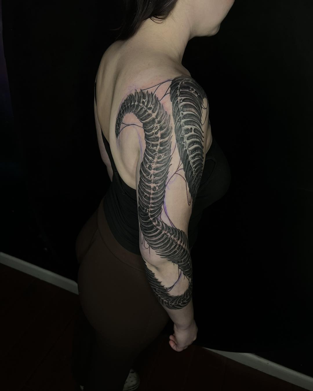 Snake black and grey tattoo on the upper arm by James Reed Tattoo artist