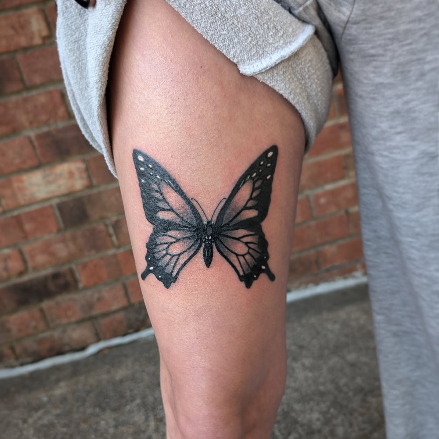 Butterfly black and grey tattoo on the thigh by Joe McElravy