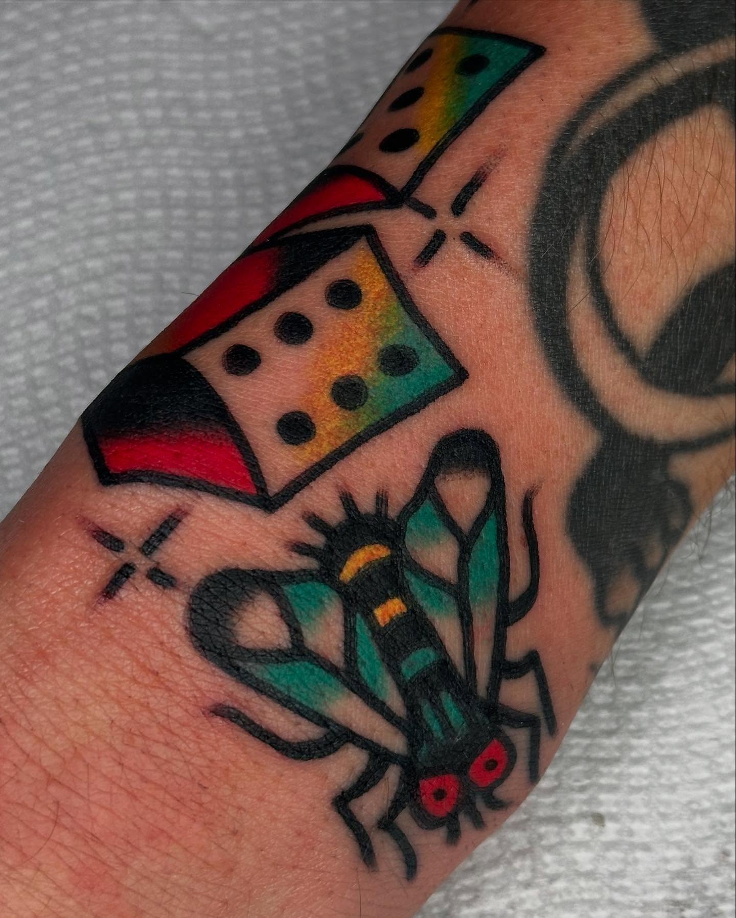 Mosquito and dice American traditional tattoo on the forearm by Steve Pearson