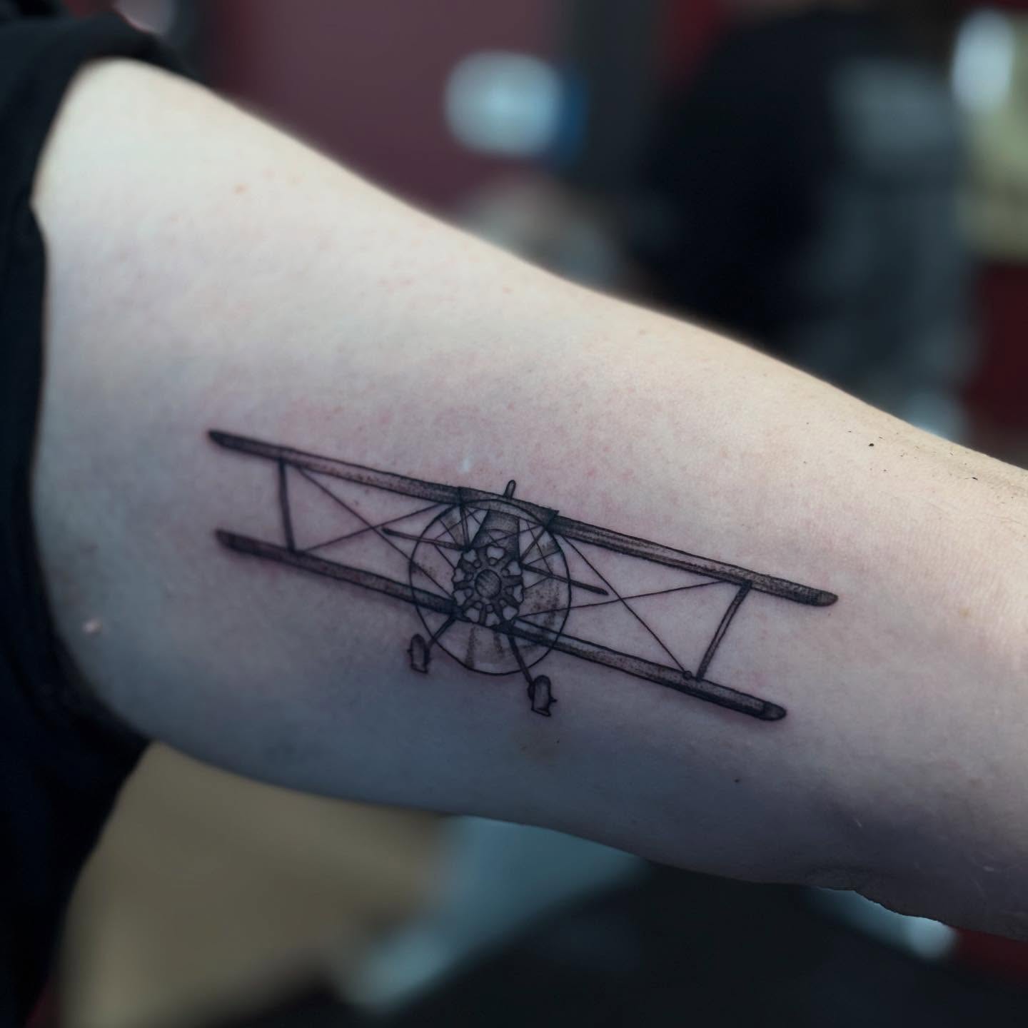 Biplane black and grey tattoo on the forearm by Gabby Finearts