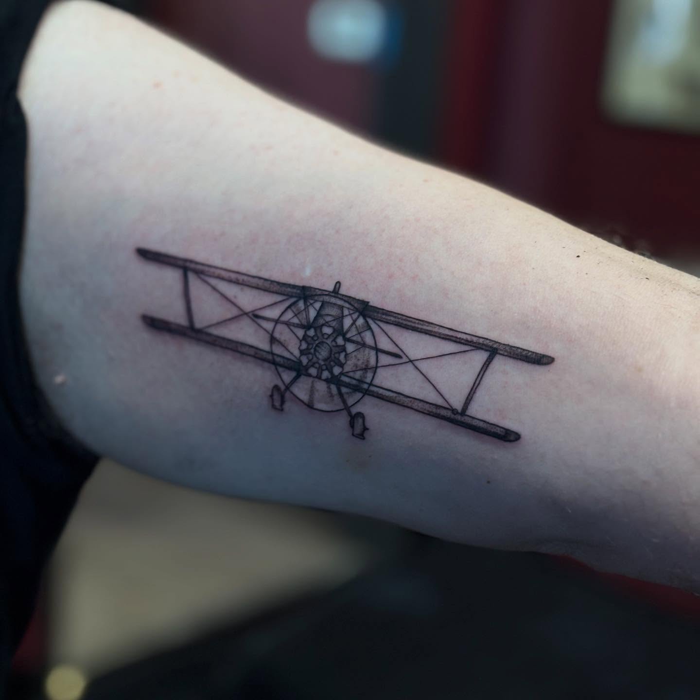 Biplane black and grey tattoo on the forearm by Gabby Finearts