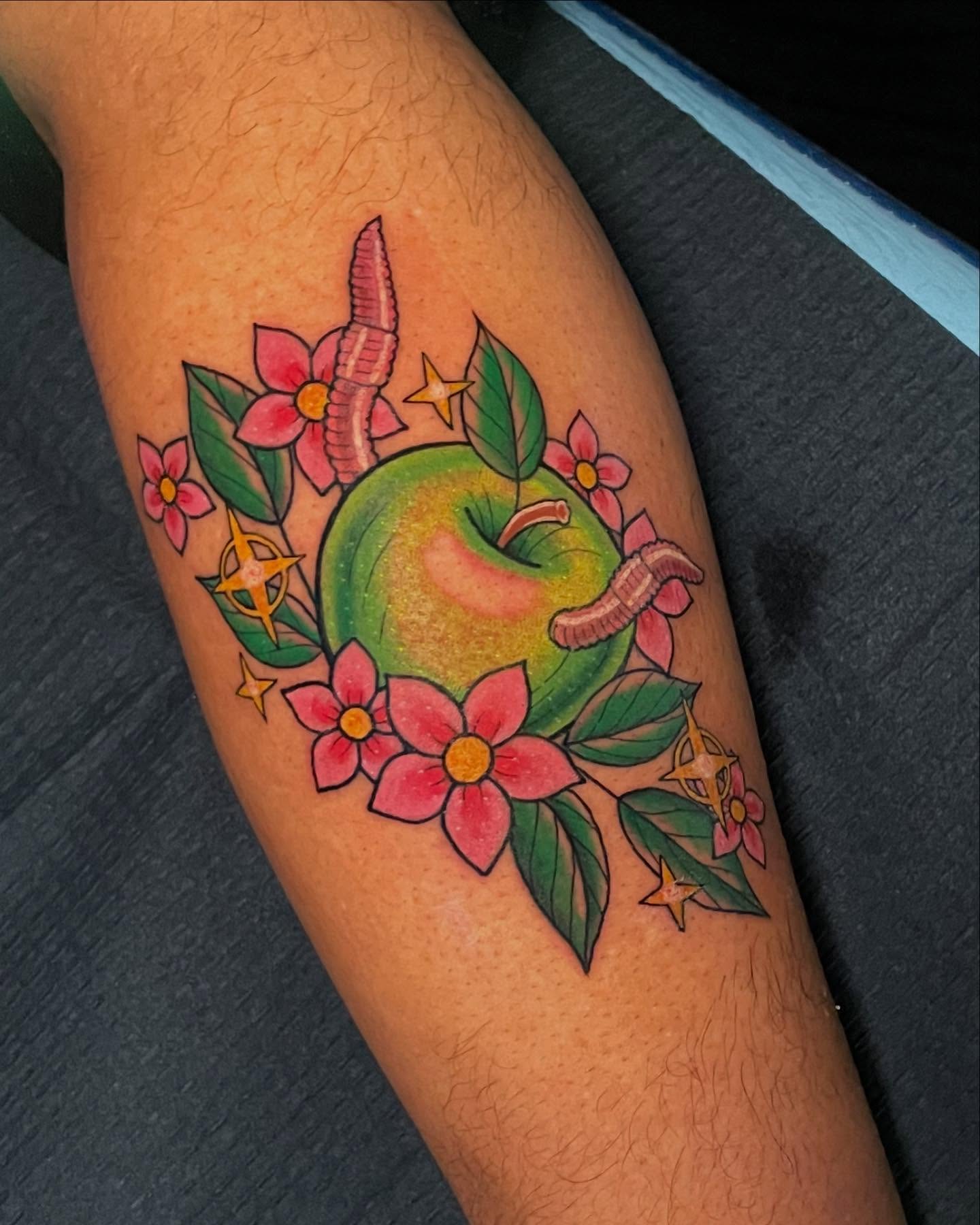 Apple with flowers new school tattoo on the forearm by Candence Smith