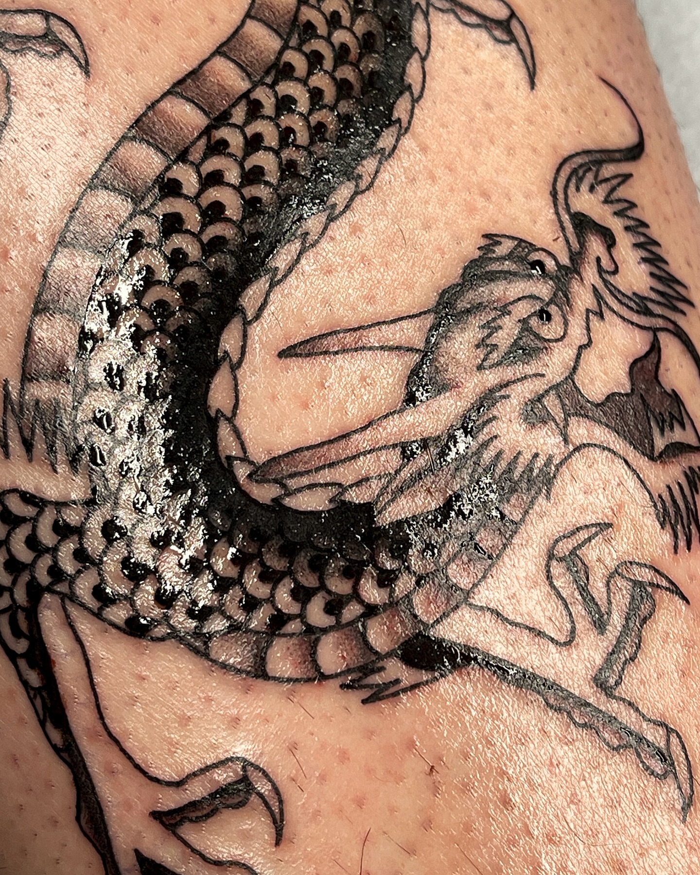 Dragon and woman black and grey tattoo on the upper arm by Chase Tucker