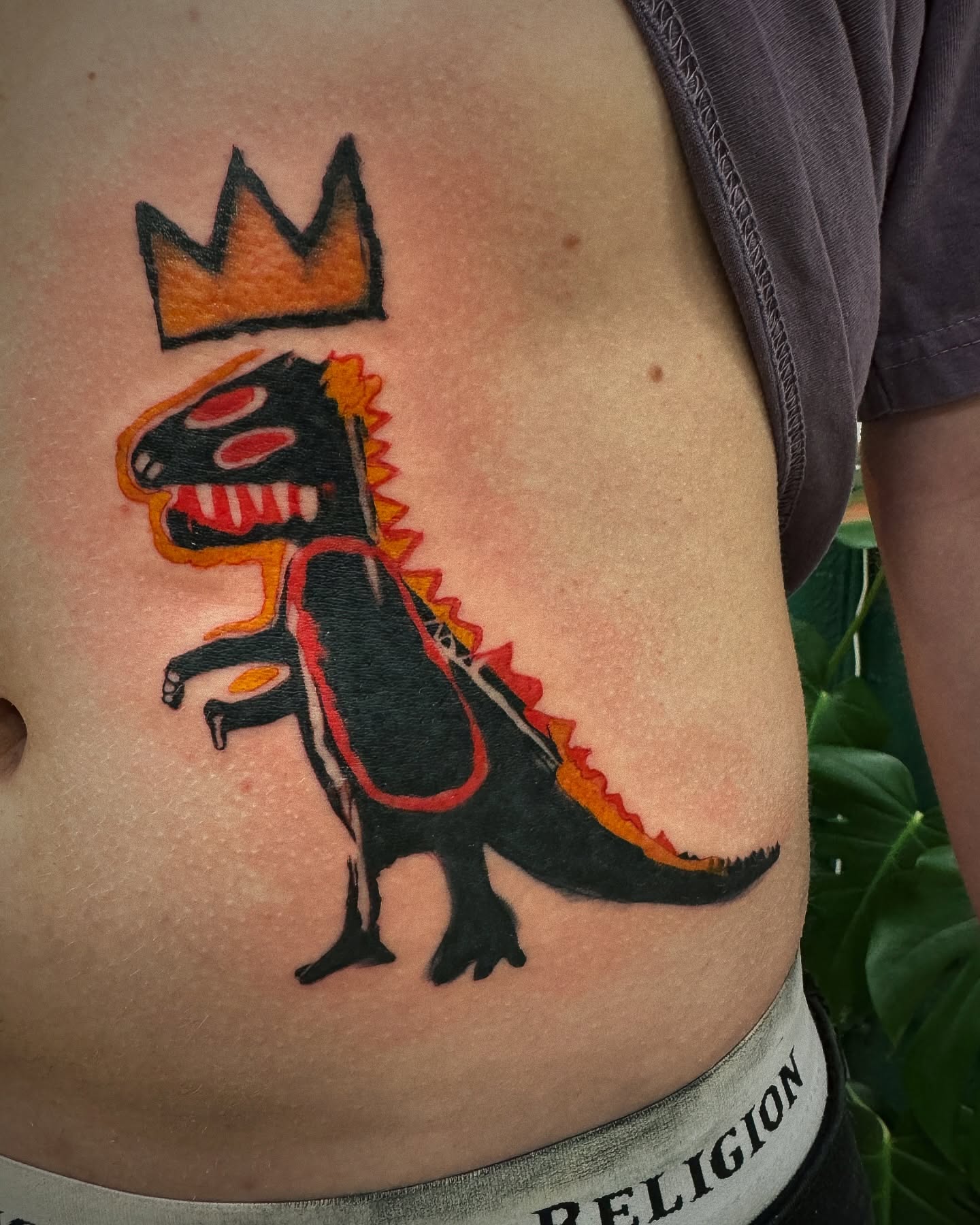 Dinosaur with crown American traditional tattoo on the ribs by 🌙Jose Maldonado🌙