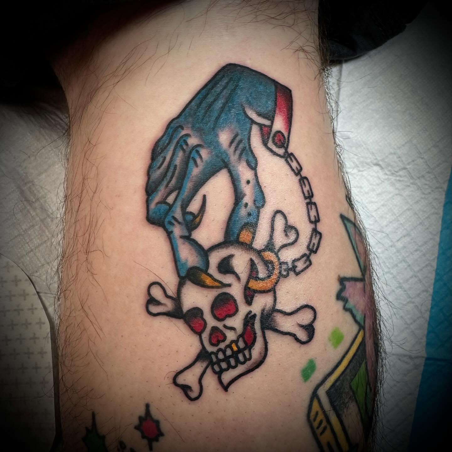 Skull and crossbones American traditional tattoo on the thigh by Olive Kelley
