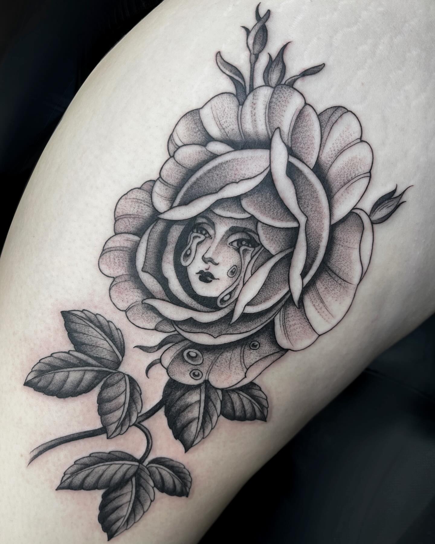 Rose with woman's face realism tattoo on the thigh by Kelsi Steffensen