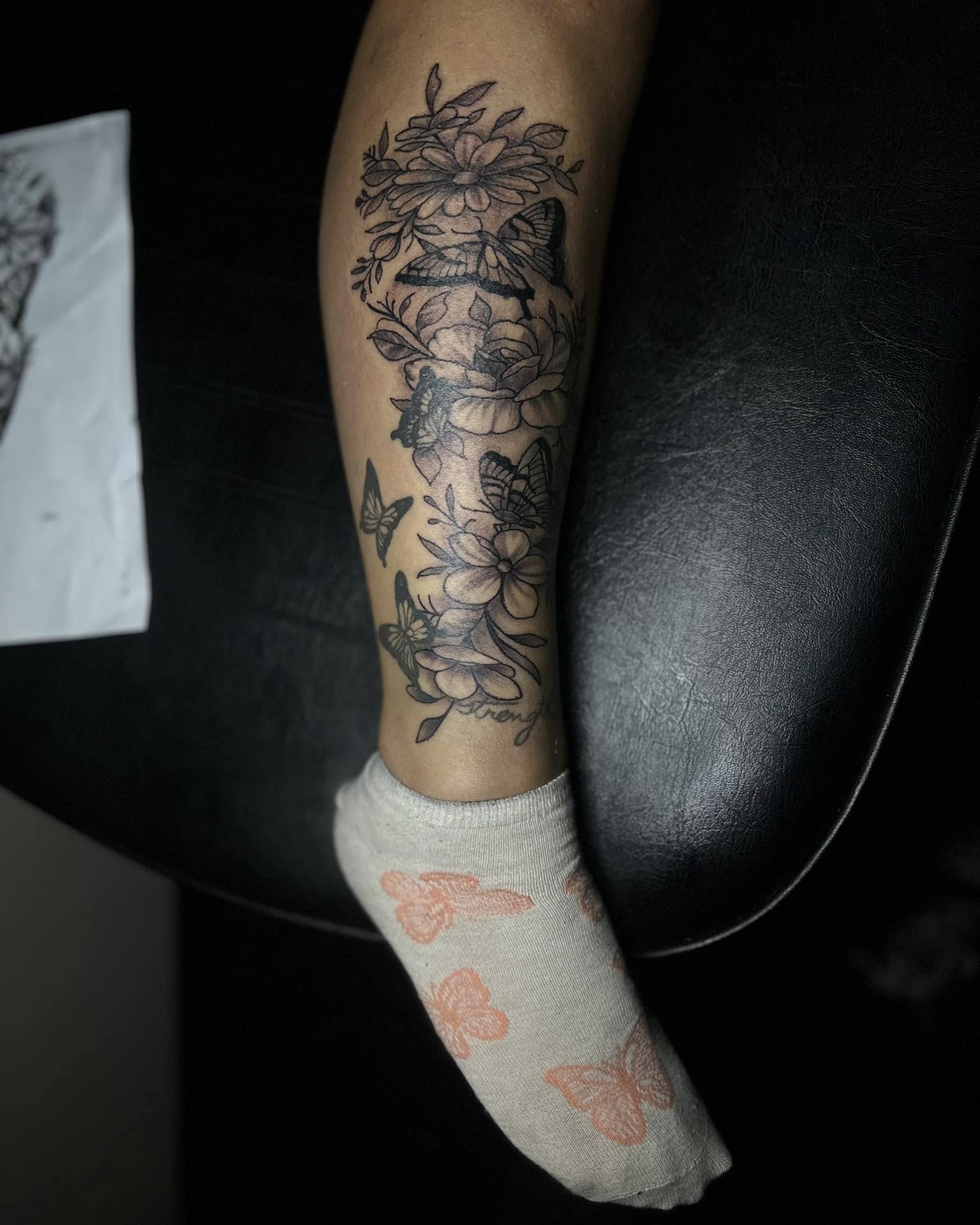 Flowers and butterflies black and grey tattoo on the forearm by Aj Negrete Jr.