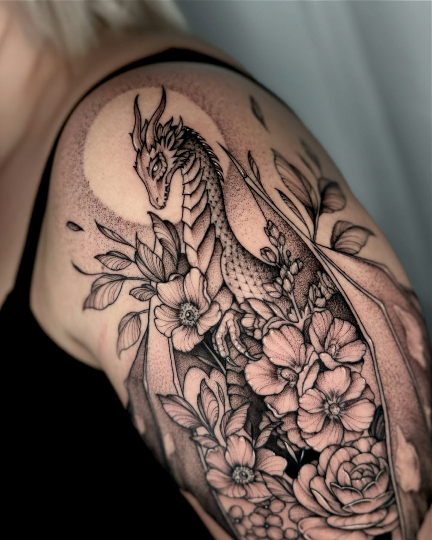 Dragon and flowers dotwork tattoo on the shoulder by Kathryn Semus