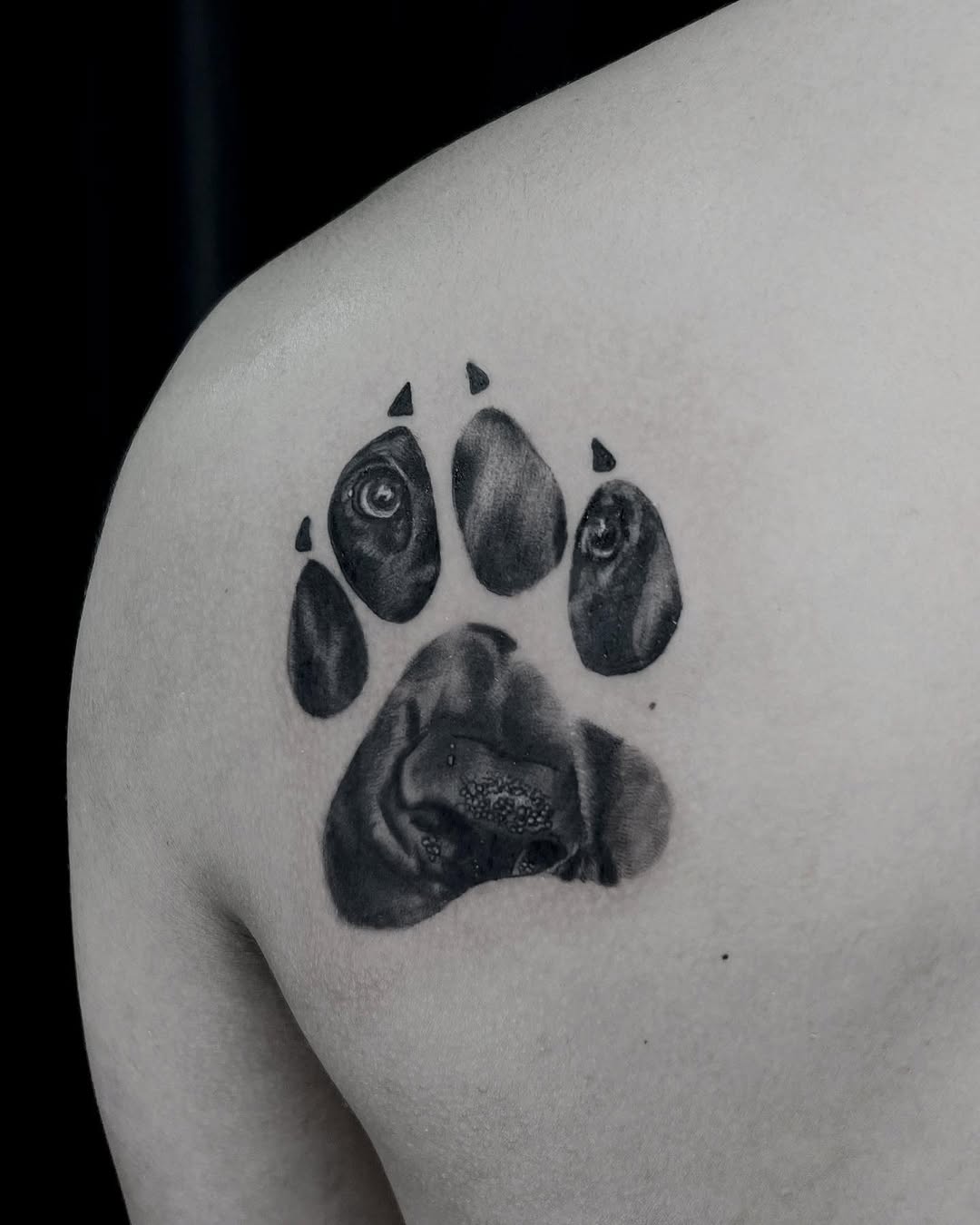 Dog paw print with dog face realism tattoo on the shoulder by Stefany🩸