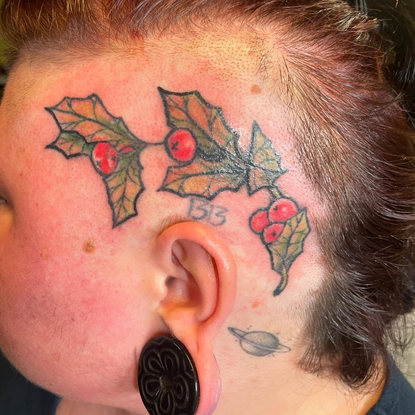 Holly leaves and berries American traditional tattoo on the head by Evan