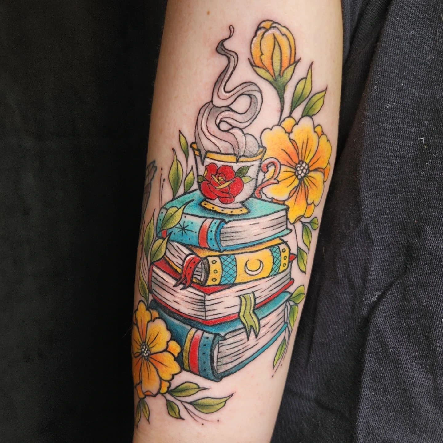Books and coffee American traditional tattoo on the forearm by Audrey Luther