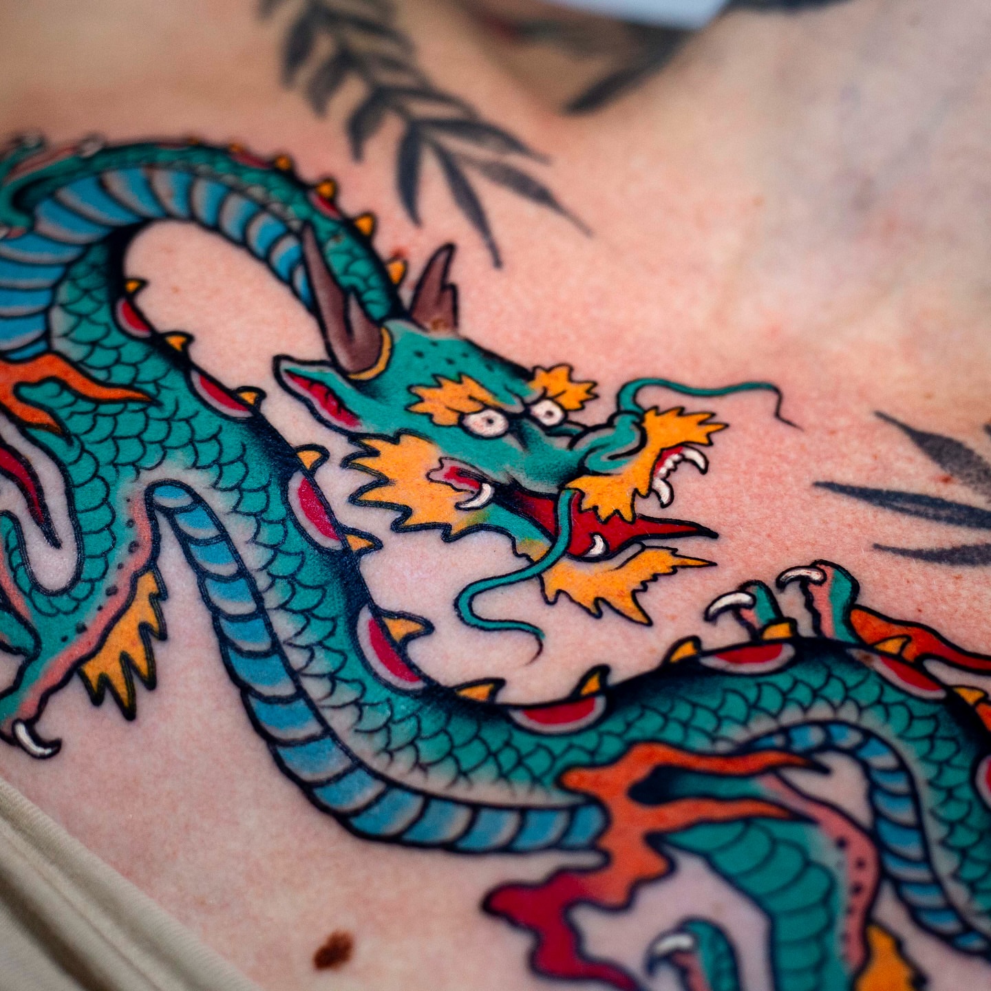 Dragon American traditional tattoo on the chest by Miguel Comin
