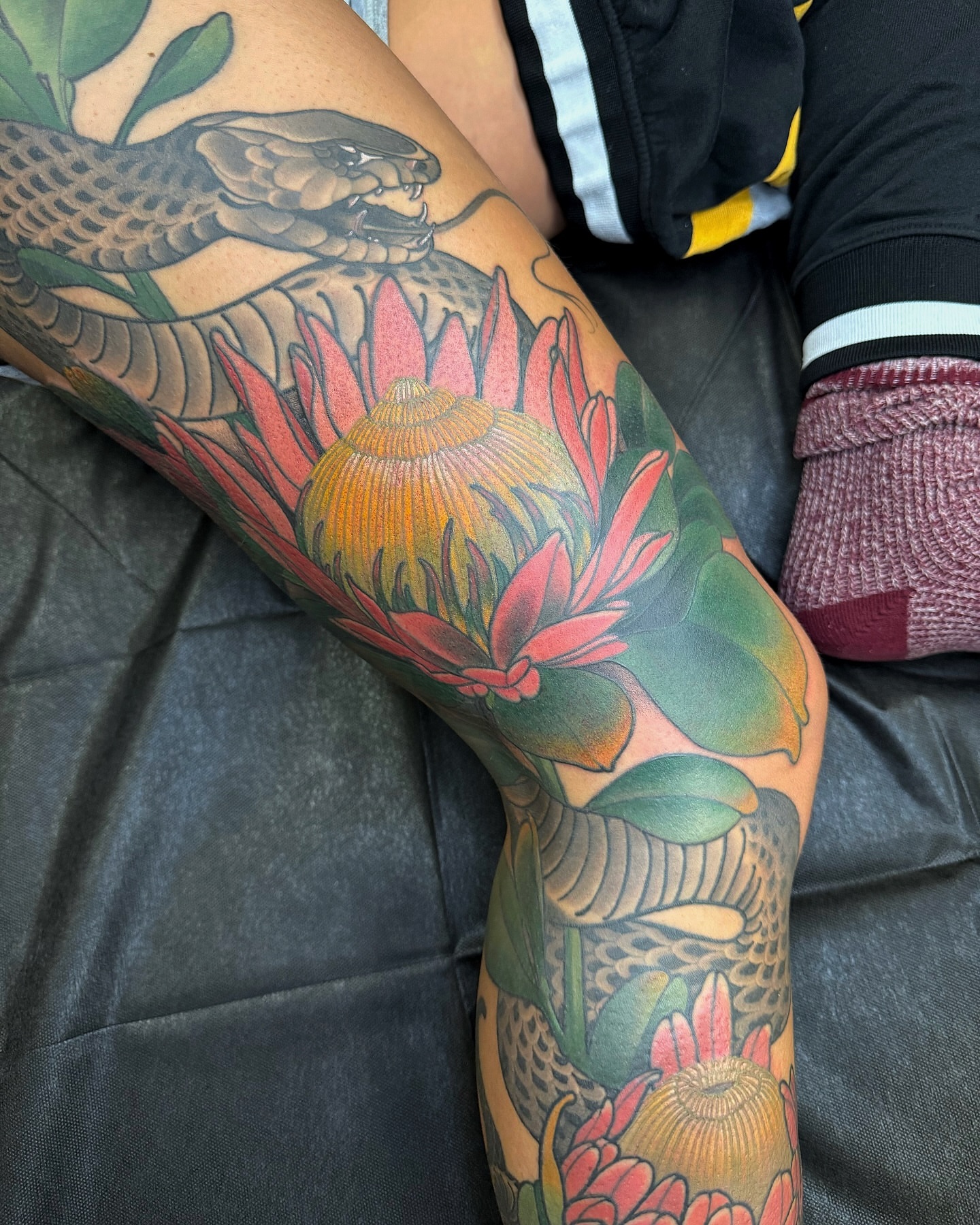Snake and flowers American traditional tattoo on the forearm by Anne Cornelson