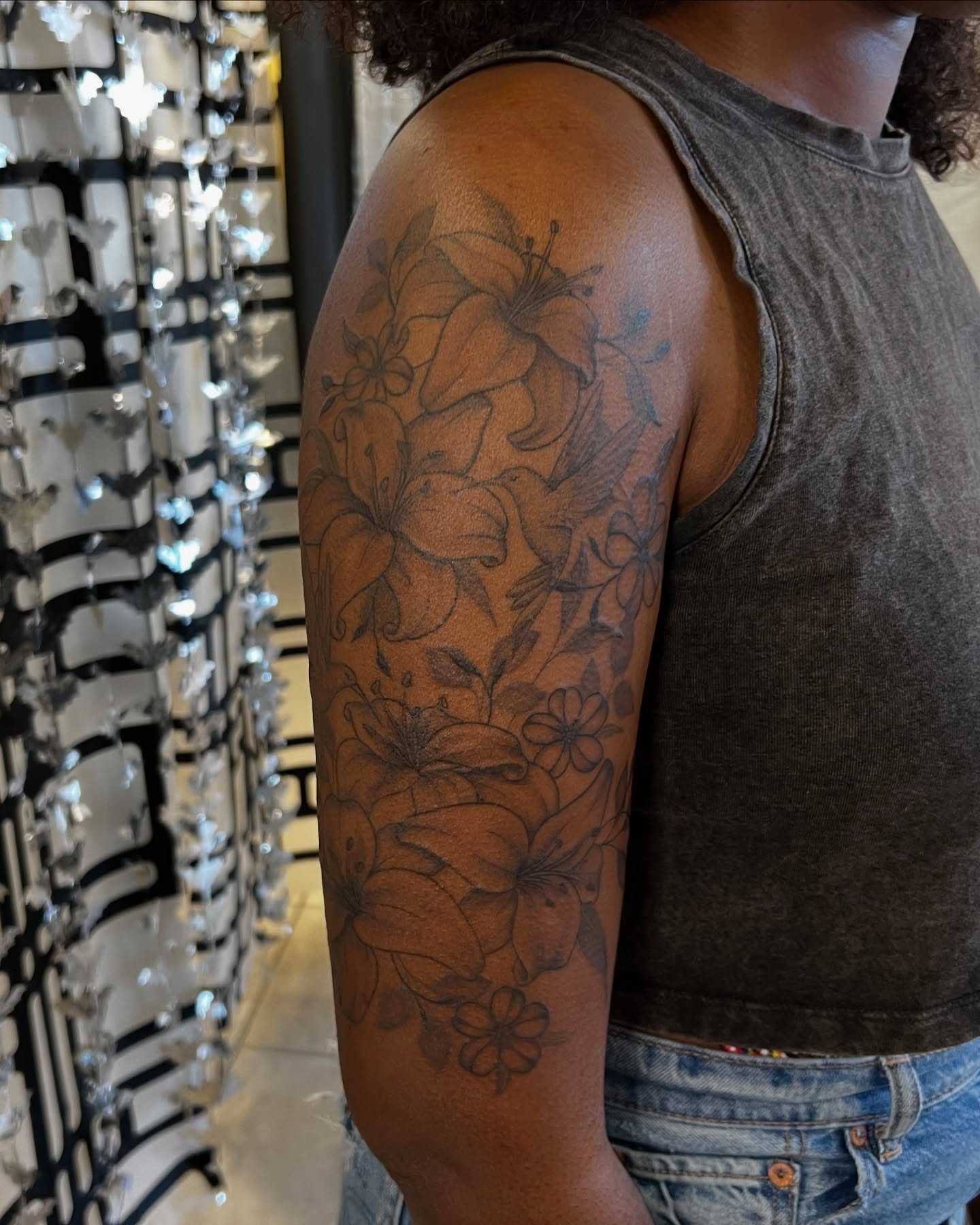 Lily flowers black and grey tattoo on the upper arm by tatman cris 🥀 dfw tattoo artist